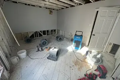 Air movers and a dehumidifier running in a home during a water damage dry-out
