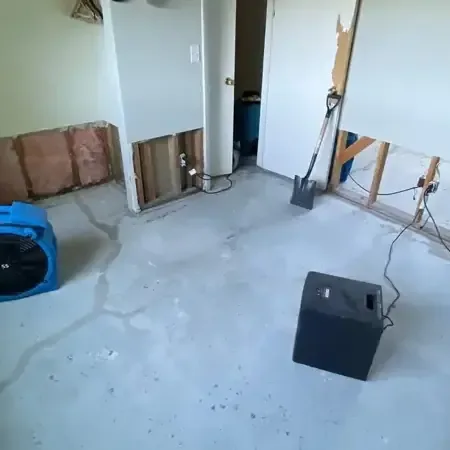 Wet-dry extractor pulling muddy water from a ground-floor hallway